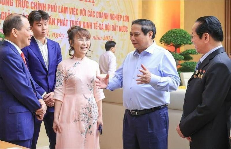 Prime Minister Pham Minh Chinh talks with Vietnamese business leaders on the sidelines of an official dialogue in Hanoi, September 21, 2024. (First, left: Vingroup chairman Pham Nhat Vuong. Middle: chairwoman of Sovico Group Nguyen Thi Phuong Thao). Photo courtesy of the government's news portal.