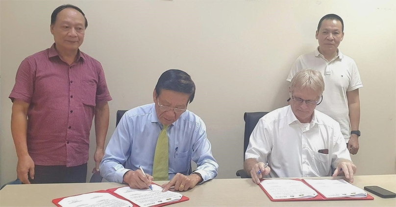 Nguyen Anh Tuan (front, left), standing vice chairman of the VAFIE, and Herr Matthias Kaiser, managing director of Avestos HR UG, sign the cooperation deal. Photo by The Investor/Nguyen Thoan.