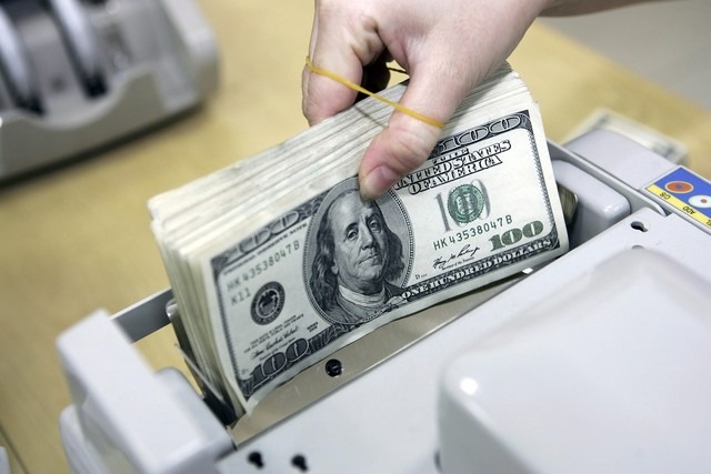 A clerk counts U.S. dollar notes at a bank in Vietnam. Photo courtesy of Thanh Nien (Young People) newspaper.