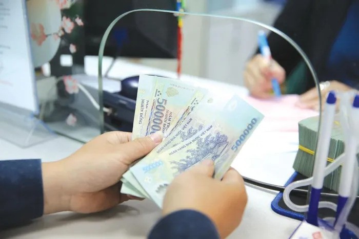  A customer deposits cash into his bank account. Photo courtesy of Saigon Times.