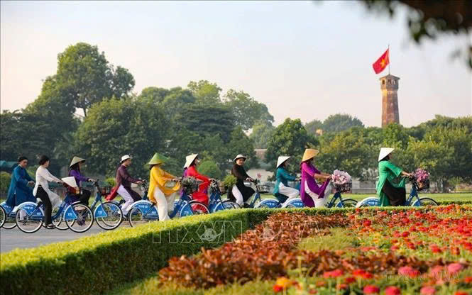 'Ao dai' wearers cycle near the Flag Tower of Hanoi. Vietnam sees the biggest improvements in diplomatic influence and cultural influence in the Asia Power Index 2024 rankings. Photo courtesy of VNA.