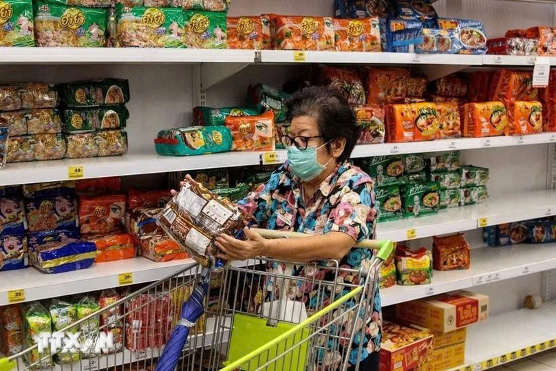  A consumer shops at a supermarket in Bangkok, Thailand. Photo courtesy of AFP/VNA.