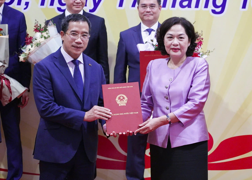 Governor of the SBV Nguyen Thi Hong (right) hands over her decision on the mandatory transfer to Luu Trung Thai, chairman of MB, in Hanoi, October 17, 2024. Photo courtesy of MB.