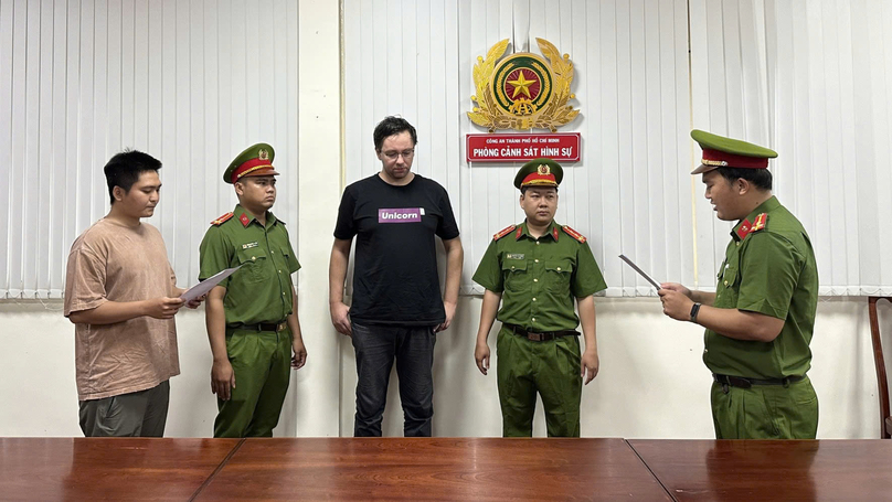 Aigars Plivės (in black) at a police station in Ho Chi Minh City. Photo courtesy of the HCMC police.