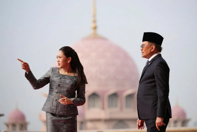 Thai Prime Minister Paetongtarn Shinawatra gestures as she talks with Malaysian Prime Minister Anwar Ibrahim with Putra Mosque in the background during a welcoming ceremony prior to their meeting in Putrajaya on December 16, 2024. Photo courtesy of Reuters.