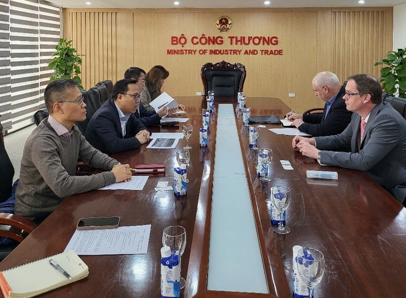 Deputy Minister of Industry and Trade Nguyen Hoang Long (left, in black) talks to Blueberry Energy's managing director Christian Schaefer (right, in glasses) on January 13, 2025. Photo courtesy of the ministry's news portal.