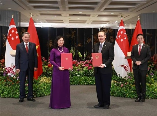 Party General Secretary To Lam and Singaporean Prime Minister Lawrence Wong witness the handover of the Joint Report on Offshore Wind Power Trade Cooperation between Vietnam and Singapore. Photo courtesy of Vietnam News Agency.