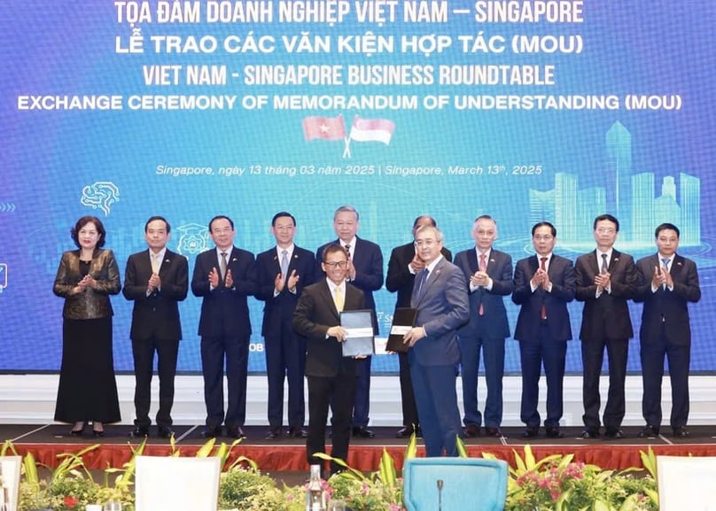 Party General Secretary To Lam and officials witness the exchange of cooperation documents between Vietnamese and Singaporean firms at a business roundtable in the city state on March 13, 2025. Photo courtesy of VNA.