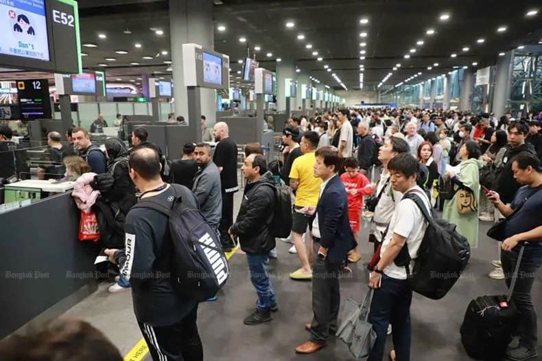 Foreign arrivals wait to go through the immigration process at Suvarnabhumi airport. Photo courtesy of Bangkok Post.