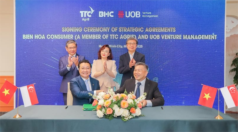 Huynh Van Phap, vice chairman of Bien Hoa Consumer (Commercial Center), and Thng Tien Tat, executive director of UOBVM, signed the strategic agreements, with the witness of Pang Te Chang, Consul General of Singapore (standing, left); Dang Huynh Uc My, chairwoman of AgriS (standing, center); and Seah Kian Wee, CEO of UOBVM (standing, right).