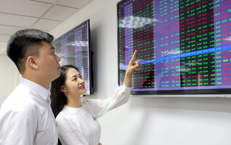Investors looking at a stock price board. Photo by The Investor/Ta Phu.