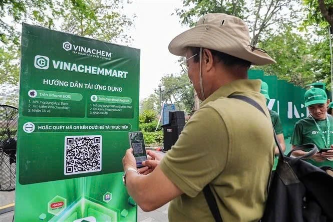 A man scans the QR code of e-commerce platform VinachemMart at the launch on May 10, 2025. Photo courtesy of Vietnam News Agency.