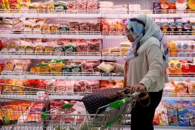 A woman shops goods at a supermarket in Indonesia. Photo courtesy of Reuters/VNA.
