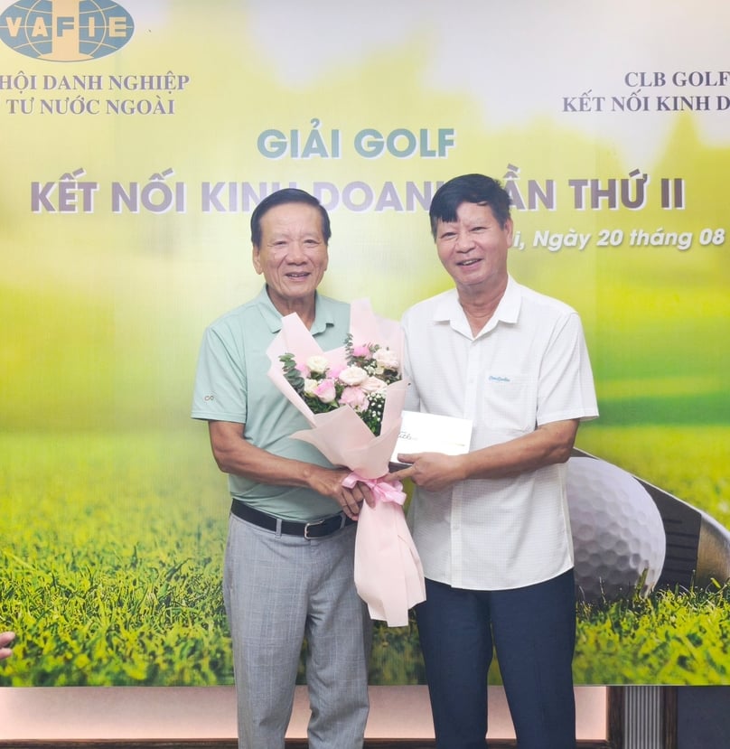 VAFIE chairman Dr. Nguyen Anh Tuan (left), head of the VAFIE “Golf Club for Business,” presents a bouquet and gift to a golfer. Photo by The Investor.