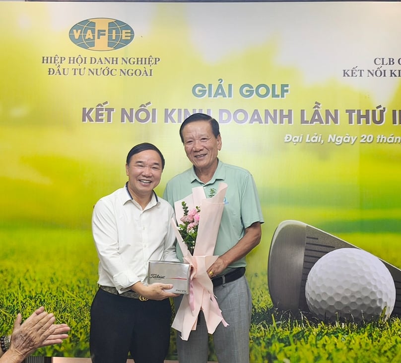 VAFIE chairman Dr. Nguyen Anh Tuan (right), head of the VAFIE “Golf Club for Business,” presents a bouquet and gift to a golfer. Photo by The Investor.