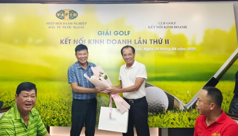 VAFIE vice chairman Nguyen Ngoc My (right) presents the consolation prize to golfer Lai Minh Tuan. Photo by The Investor.