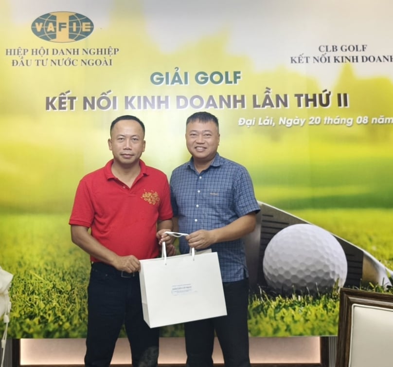 Editor-in-Chief of The Investor and VAFIE Executive Committee member Pham Duc Son (left) presents the Nearest-to-Pin prize to golfer Truong Anh Tuan. Photo by The Investor.