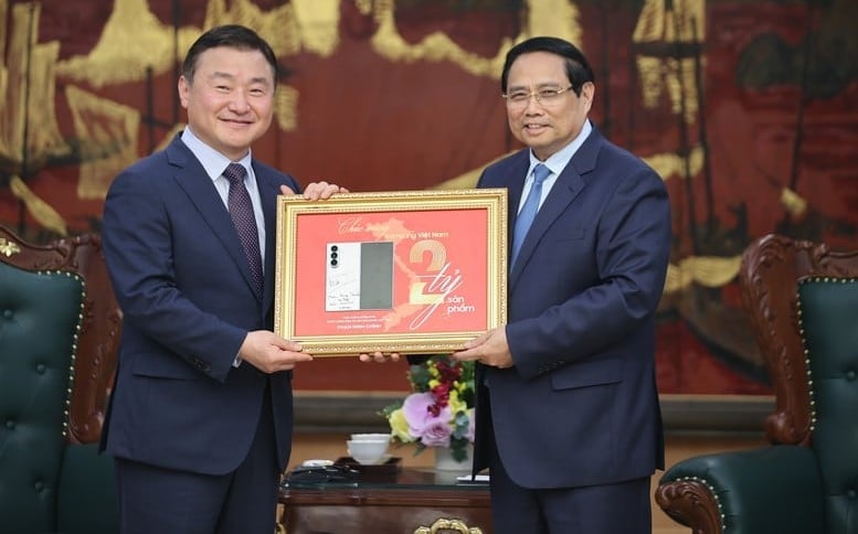 Prime Minister Pham Minh Chinh hands over a plaque commemorating the production of Samsung's 2 billionth mobile phone in Vietnam to Roh Tae Moon, acting head of Samsung Electronics's consumer and smartphone business. Photo courtesy of the government's news portal.