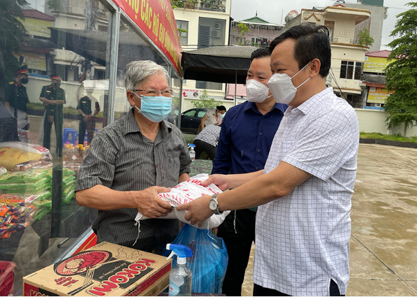  Đại diện lãnh đạo quận Đống Đa trao hỗ trợ người dân trong đợt dịch thứ 4. Ảnh minh họa.