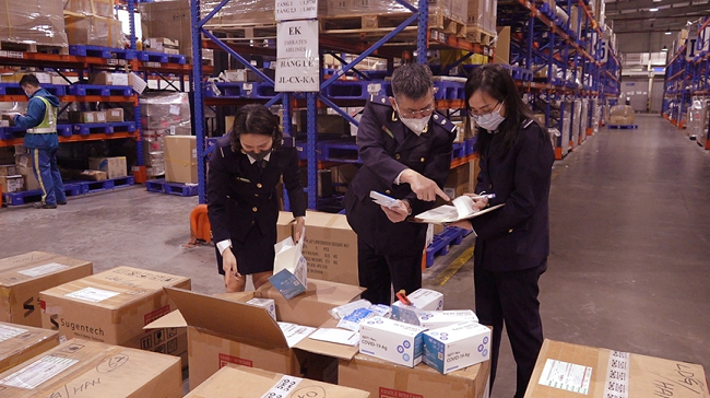 Lực lượng chức năng tiến hành kiểm tra lô hàng vi phạm. Ảnh: Tổng cục Hải quan
