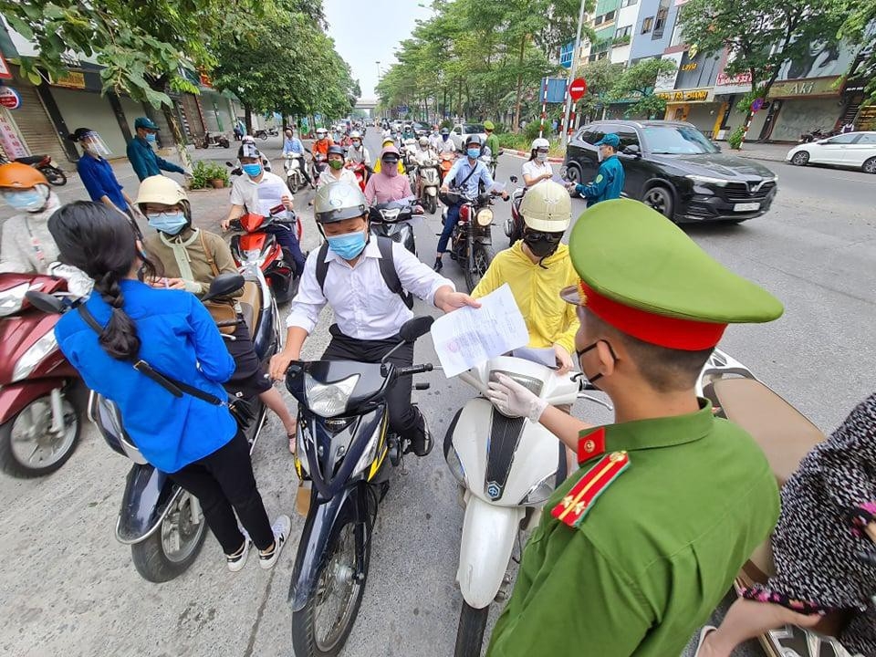 Lực lượng chức năng tại chốt kiểm soát kiểm tra giấy tờ đi đường của người dân.