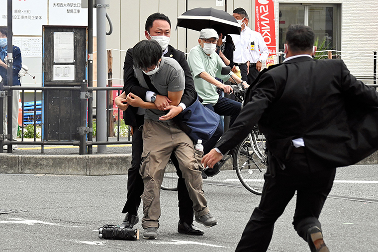 Nghi phạm vụ nổ súng bị bắt giữ bên cạnh khẩu súng tự chế. Ảnh: Asahi Shimbun