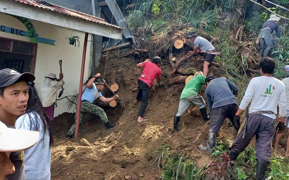  Nhân viên cứu hộ và người dân đào xung quanh một tòa nhà sau trận lở đất ở Mayag, Philippines hôm 27/7. (Ảnh: AFP)