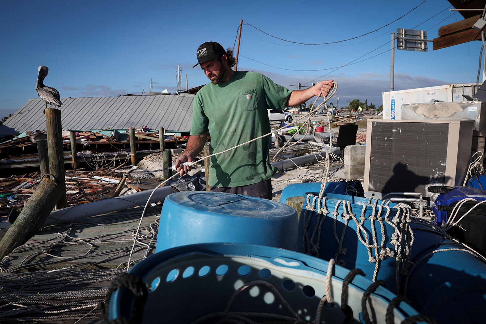  Anh Mike McPhillips trục vớt dây kéo lưới sau bão Ian khiến nước biển dâng gần Bãi biển Fort Myers. (Nguồn ảnh: Win McNamee / Getty Images)