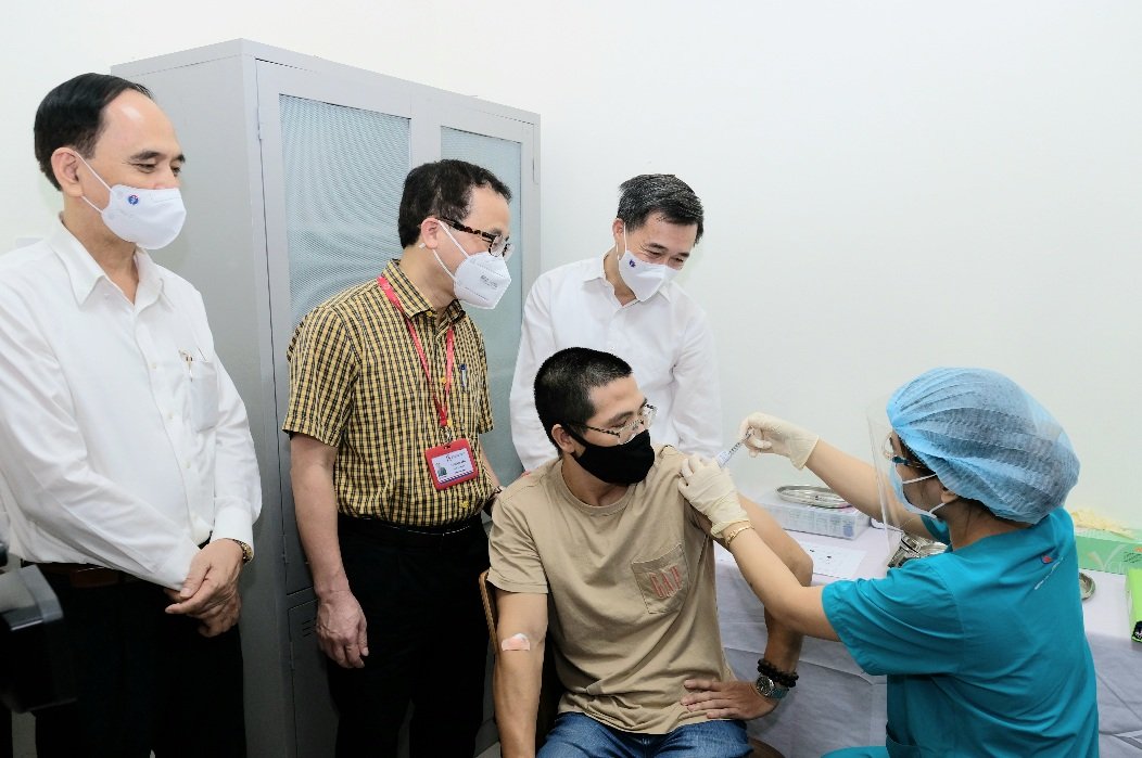 Thứ trưởng Bộ Y tế Trần Văn Thuấn trò chuyện với người tiêm tình nguyện đầu tiên vaccine ARCT-154 phòng COVID-19. Ảnh: Trần Minh 