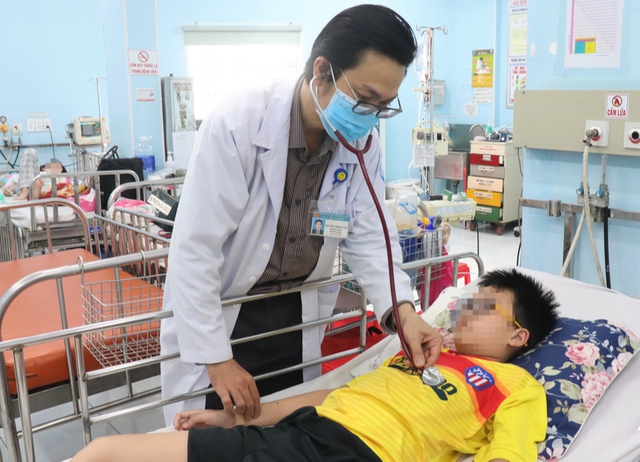 TS.BS Nguyễn Minh Tuấn - Trưởng khoa Sốt xuất huyết - Huyết học Bệnh viện Nhi đồng 1 (TP.HCM), thăm khám bệnh nhân bị sốt xuất huyết. Ảnh: Xuân Mai 