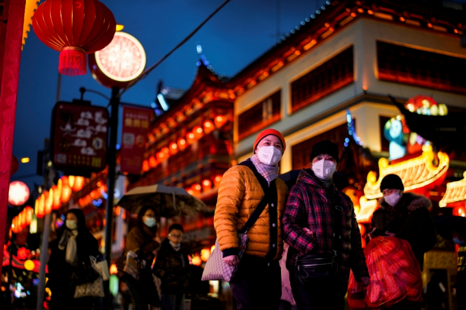 Người dân mặc ấm, đeo khẩu trang khi đi dạo trong khu vực trang trí đèn lồng trước Tết Nguyên đán ở thành phố Thượng Hải, Trung Quốc hôm 28/1. Ảnh: Reuters