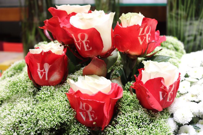 Hoa hồng đỏ ở Việt Nam cũng khan hiếm. Nhiều cửa hàng phủ nhuộm màu đỏ những cánh hoa bên ngoài hồng trắng và phun in chữ 'LOVE' trông lạ mắt để thu hút khách. Ảnh: IT