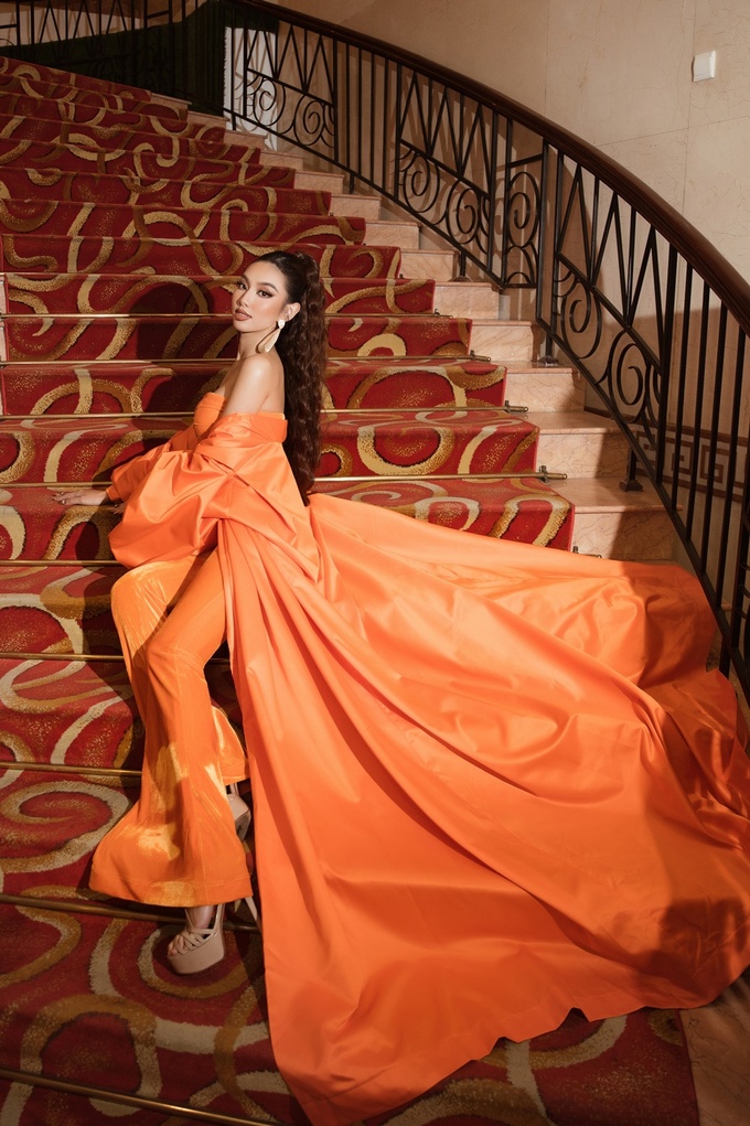 Xuất hiện rất sớm, Hoa hậu Thuỳ Tiên trong jumpsuit màu cam rực rỡ với những đường cắt sẻ tạo nên thương hiệu của Thuỳ Tiên. Nàng hậu 98 thiêu đốt mọi ánh nhìn.