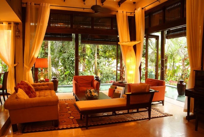Phòng khách thoáng đãng, giao hòa với thiên nhiên nhưng cũng vô cùng ấm áp nhờ vào nội thất gam màu nóng và ánh đèn vàng.