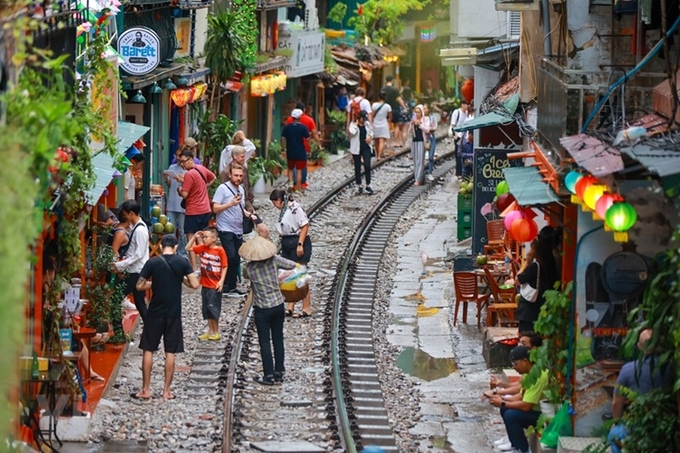 Đường sắt kiến nghị xử lý dứt điểm tình trạng buôn bán, chụp ảnh tại tụ điểm cà phê đường tàu, tránh nguy cơ mất an toàn giao thông. Ảnh: Vietnam+