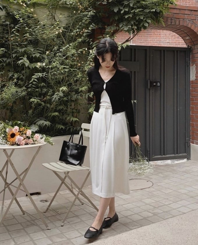 Chiếc váy màu trắng phối cùng chiếc áo khoác màu đen mỏng rất xinh xắn cho các cô nàng có ngoại hình ngọt ngào. Đôi giày búp bê càng tạo nên tổng thể hoàn hảo.