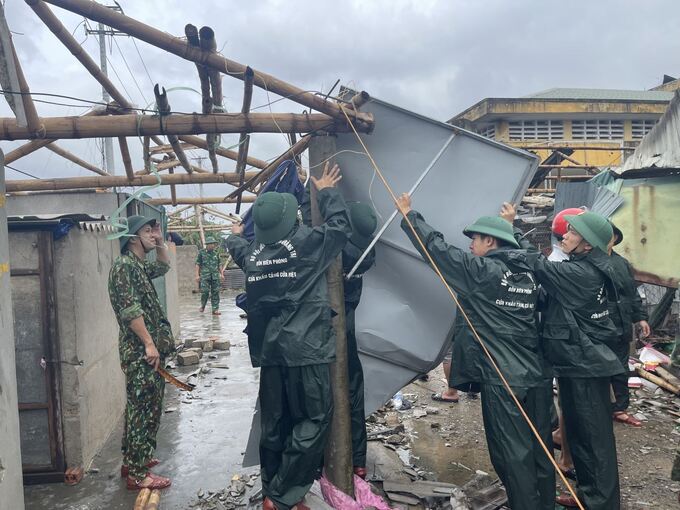 Cán bộ, chiến sĩ Đồn biên phòng Cửa Việt, Quảng Trị giúp đỡ nhân dân khắc phục hậu quả mưa bão. Ảnh: BĐBP cung cấp