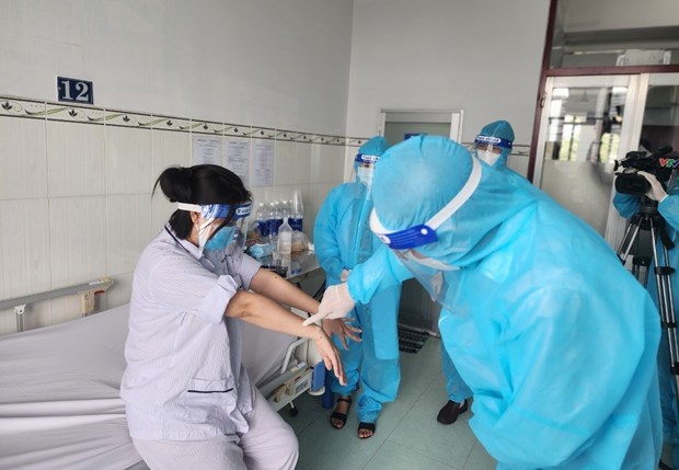 Lãnh đạo Cục Y tế dự phòng thăm hỏi, động viên người bệnh mắc đậu mùa khỉ đầu tiên tại Việt Nam. Ảnh: TTXVN