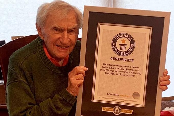 Tiến sĩ Howard Tucker chụp với tấm bằng được kỷ lục Guinness công nhận. Ảnh: UPI