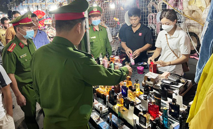 Lực lượng chức năng kiểm tra hàng hóa bày bán tại chợ đêm phố cổ Hà Nội. Ảnh: IT