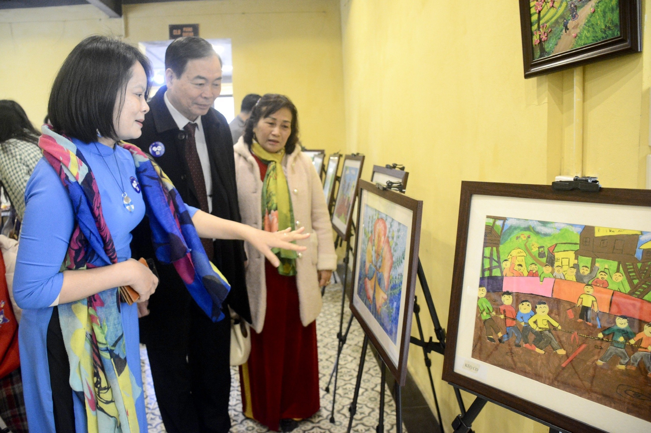 Các đại biểu tham quan triển lãm tranh do trẻ khiếm thính vẽ. 