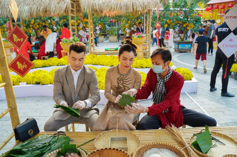 Ưng Hoàng Phúc và Kim Cương cùng nhau gói bánh chưng tại gian hàng tết truyền thống của Hội Hoa Xuân 2022