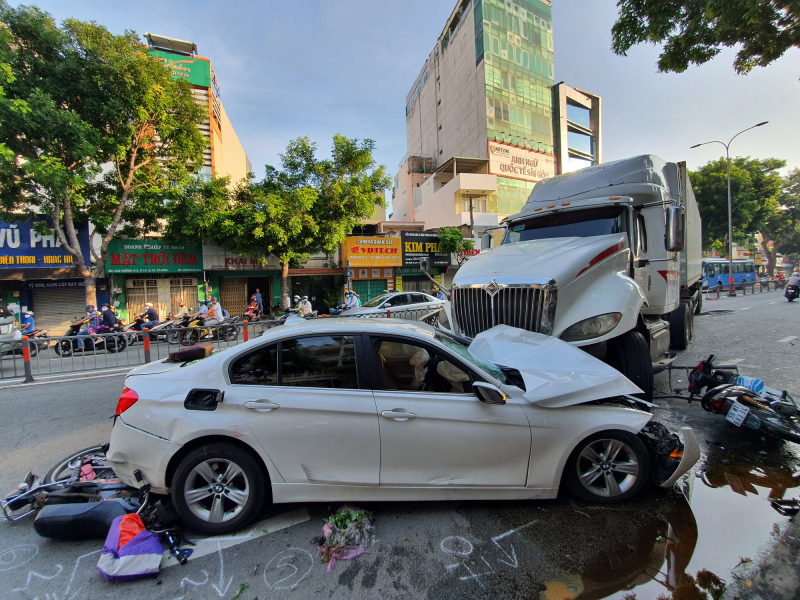 Tin tức tai nạn giao thông mới nhất ngày 22/9: Container tông BMW biến dạng và cuốn nhiều xe máy vào gầm. (Ảnh: Báo PHÁP LUẬT & BẠN ĐỌC)