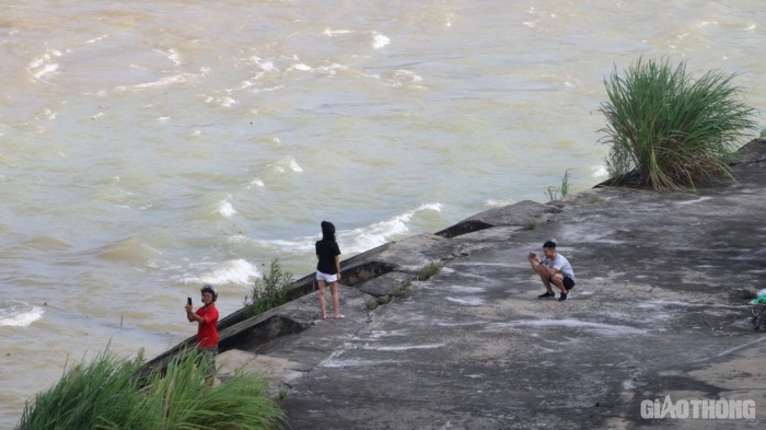 Nhiều người xuống sát bờ sông để chụp ảnh. (Ảnh: Baogiaothong)