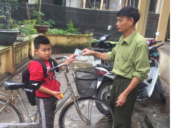 Hà Nội: Học sinh lớp 4 nhặt được tiền liền đạp xe đến giao cho công an. (Ảnh: Nhipsongviet)