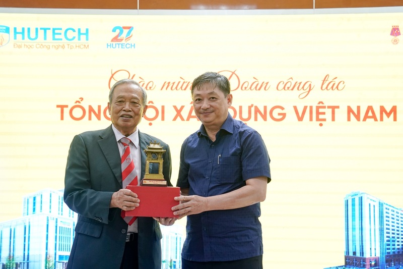 TS Kiều Tuân, Thường trực Hội đồng Trường Đại học Công nghệ TP HCM trao quà lưu niệm của nhà trường cho TS Đặng Việt Dũng - Chủ tịch Tổng hội Xây dựng Việt Nam.