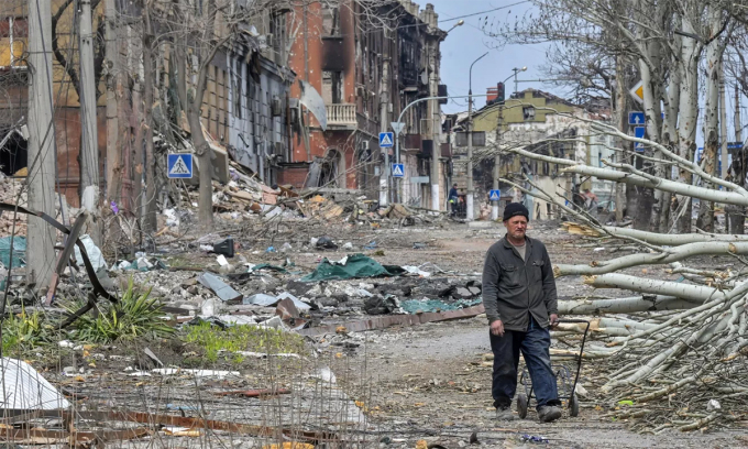 Người đàn ông đi qua con phố với những ngôi nhà bị hư hại trong giao tranh tại thành phố Mariupol, miền nam Ukraine ngày 8/4. Ảnh: RIA Novosti.