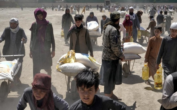 Người dân Afghanistan nhận khẩu phần lương thực viện trợ ở Kabul ngày 30/4. Ảnh: AP.