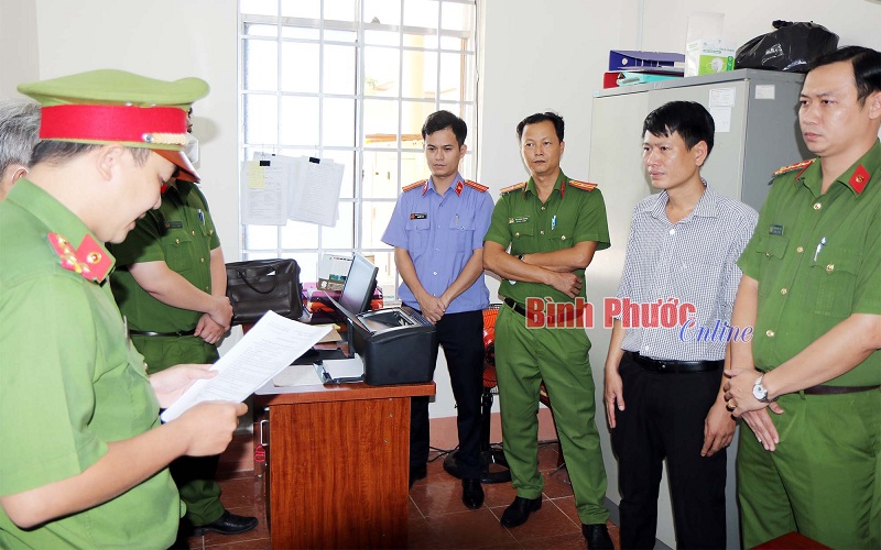 Lực lượng chức năng tống đạt quyết định và thực hiện lệnh bắt tạm giam, khám xét nơi ở, nơi làm việc đối với nhân viên khoa Dược thuộc CDC Bình Phước - Lê Thành Bắc. (Ảnh: Báo Bình Phước).