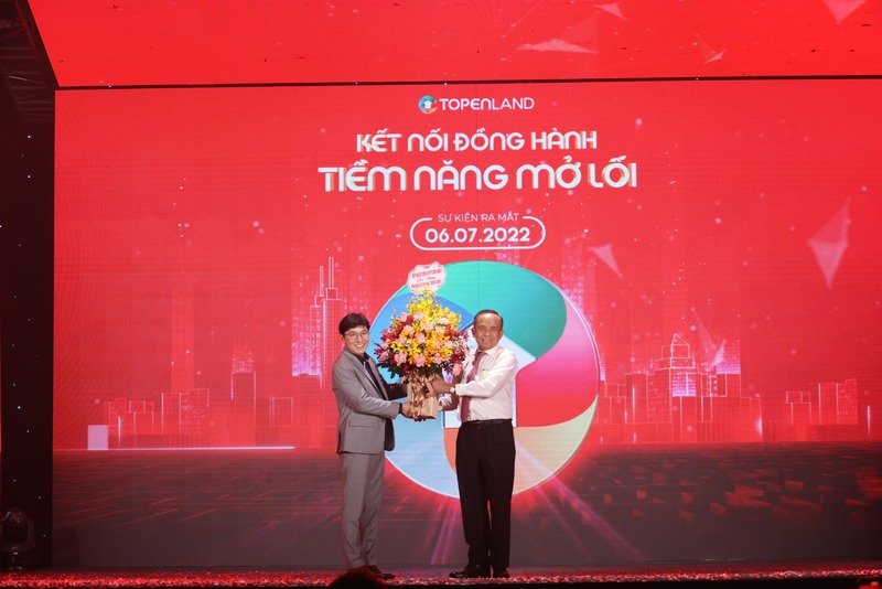 Ông Lê Hoàng Châu(bên phải)-Chủ tịch Hiệp hội Bất động sản Tp.HCM tặng hoa cho ông Trần Quang Trình-Tổng Giám đốc TopenLand trong sự kiện ra mắt nền tảng TopenLand